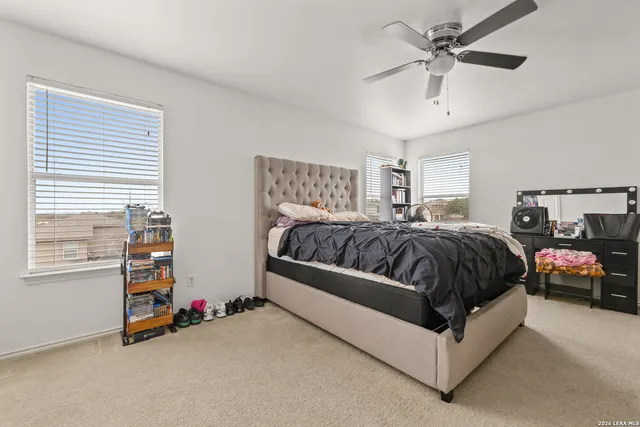 a spacious bedroom with a bed a window and a chandelier