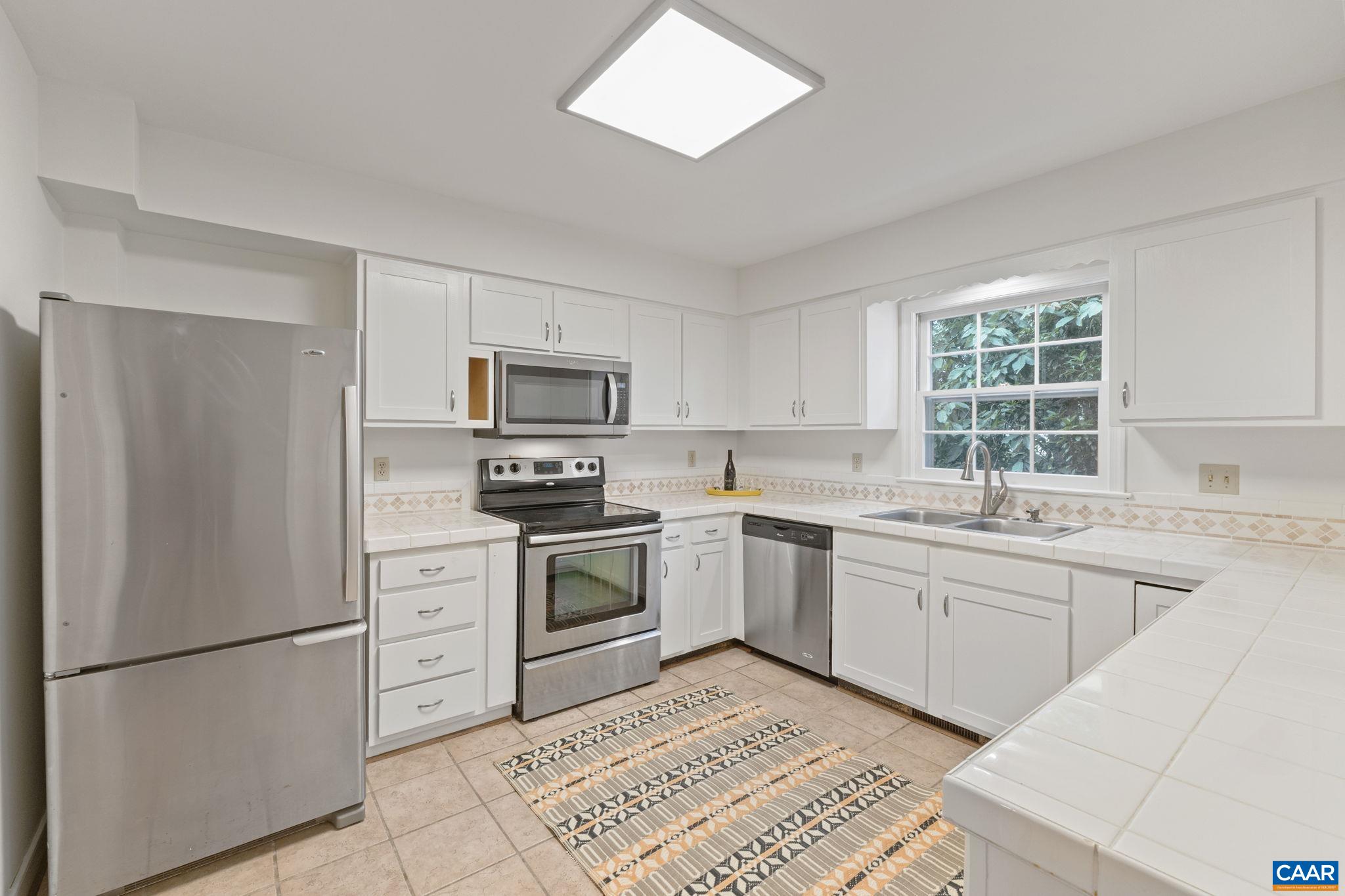 2752 Hydraulic Road Charlottesville, VA 22901 - Photo 12 of 41 a kitchen with granite countertop appliances a sink cabinets and a window