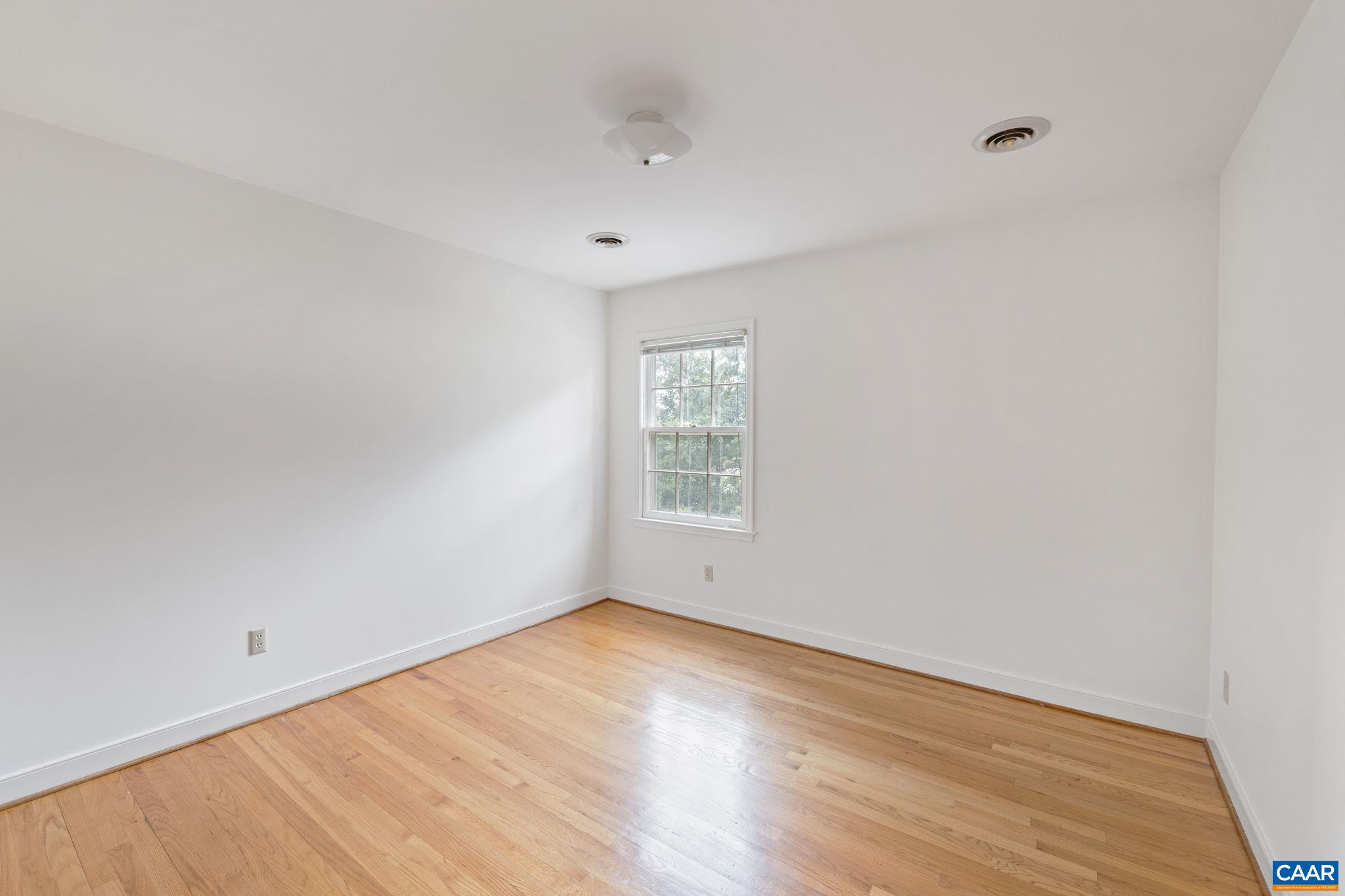 2752 Hydraulic Road Charlottesville, VA 22901 - Photo 26 of 41 a view of an empty room with wooden floor and a window