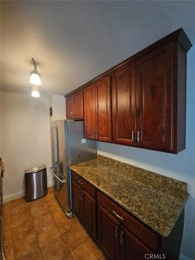 75 Western Shore Lane, Unit 1 San Francisco, CA 94102 - Photo 11 of 17 a kitchen with stainless steel appliances granite countertop wooden cabinets a refrigerator and a sink