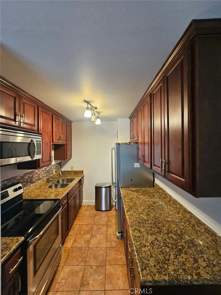 75 Western Shore Lane, Unit 1 San Francisco, CA 94102 - Photo 9 of 17 a kitchen with stainless steel appliances granite countertop a stove refrigerator and microwave