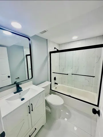 a bathroom with a double vanity sink toilet mirror and shower