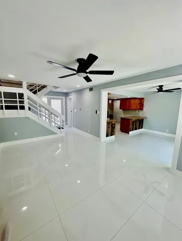 a living room with stainless steel appliances kitchen island granite countertop a stove and a refrigerator