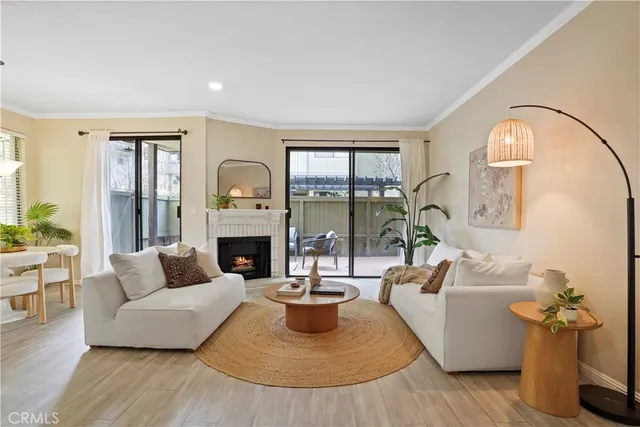 a living room with furniture a fireplace and a large window