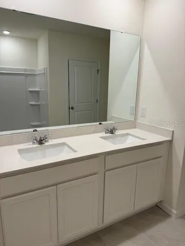 a bathroom with a double vanity sink and a mirror