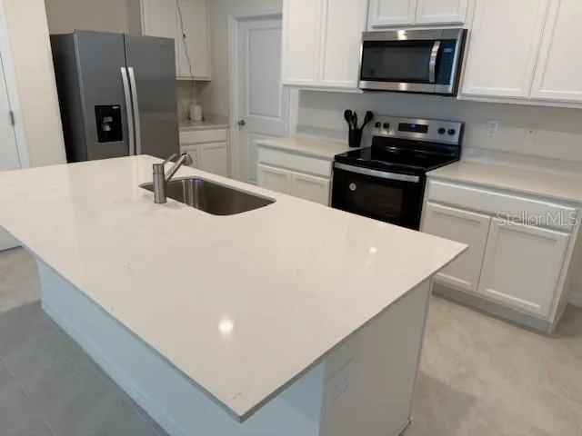 a kitchen with stainless steel appliances a refrigerator stove microwave and sink