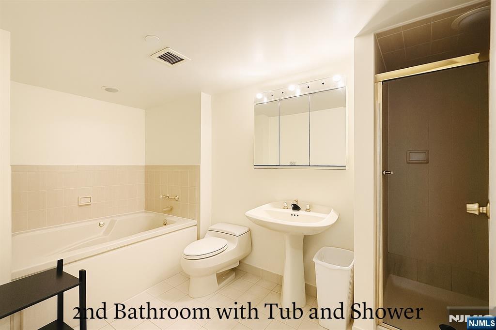 1265 15th Street, Unit 1A Fort Lee, NJ 07024 - Photo 11 of 14 a bathroom with a toilet a sink and bathtub