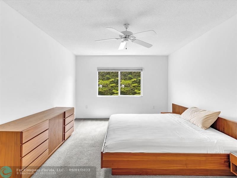 9551 Weldon Circle, Unit E311 Tamarac, FL 33321 - Photo 24 of 64 a bedroom with a large bed and a window