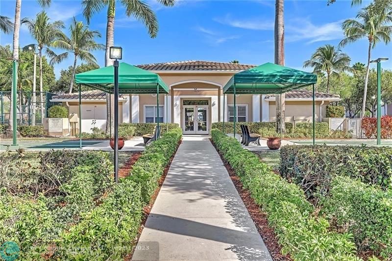 9551 Weldon Circle, Unit E311 Tamarac, FL 33321 - Photo 38 of 64 a front view of a house with a yard and potted plants