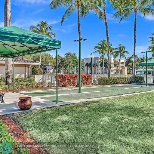 9551 Weldon Circle, Unit E311 Tamarac, FL 33321 - Photo 40 of 64 a view of a backyard with plants and palm trees