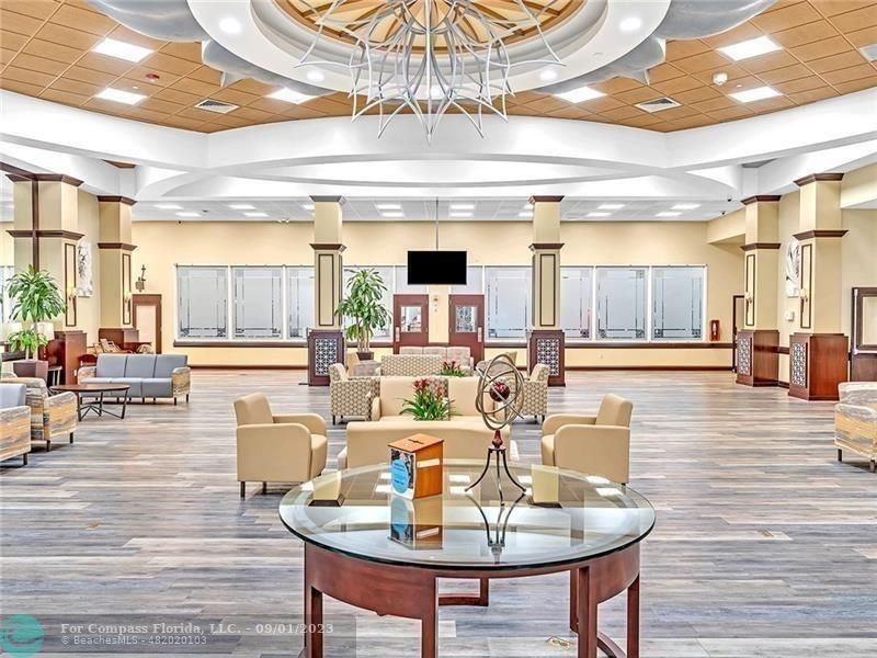 9551 Weldon Circle, Unit E311 Tamarac, FL 33321 - Photo 52 of 64 a living room with furniture and a chandelier