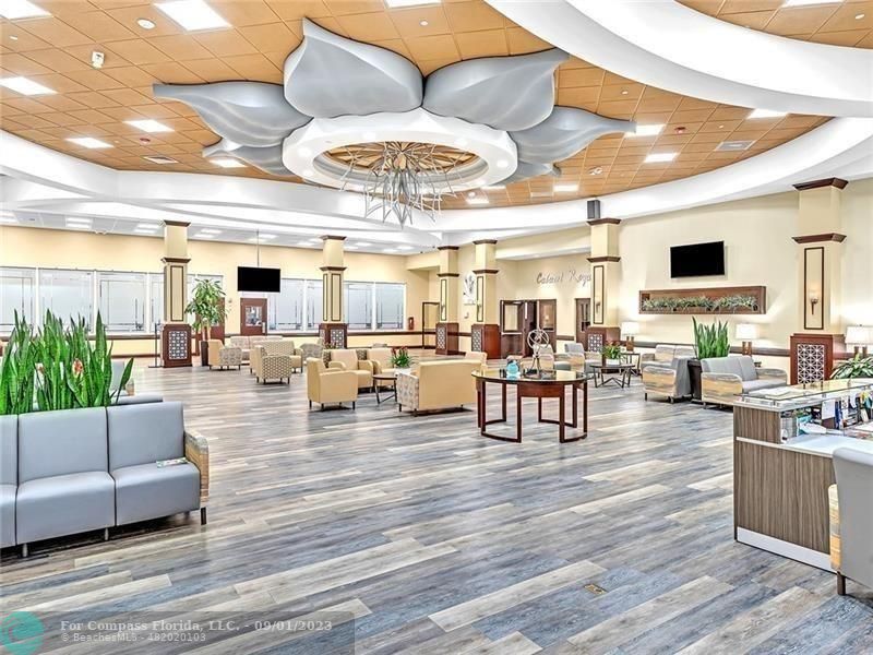 9551 Weldon Circle, Unit E311 Tamarac, FL 33321 - Photo 53 of 64 a living room with lots of furniture and view of kitchen