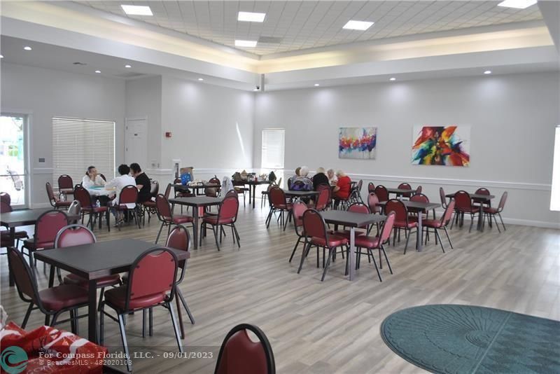 9551 Weldon Circle, Unit E311 Tamarac, FL 33321 - Photo 61 of 64 a view of a dining room with furniture wooden floor and chandelier