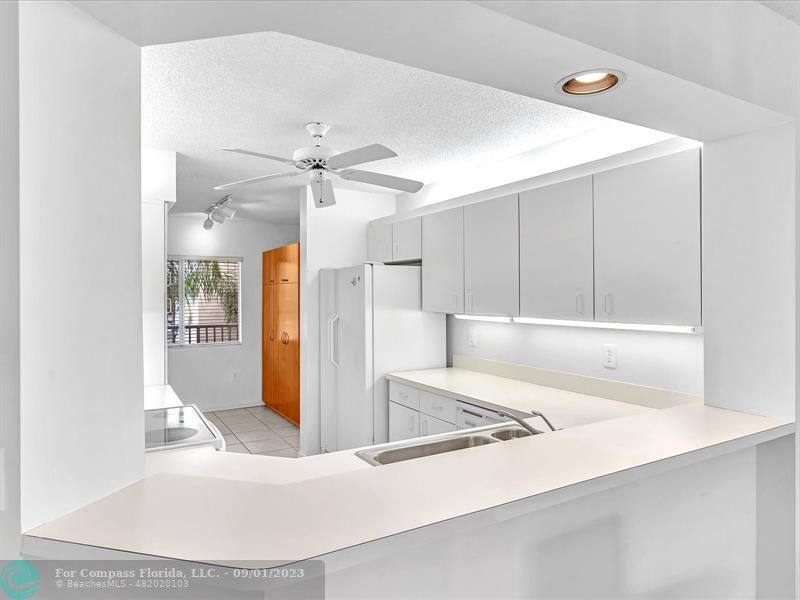 9551 Weldon Circle, Unit E311 Tamarac, FL 33321 - Photo 9 of 64 a view of a kitchen with a sink a refrigerator and a window