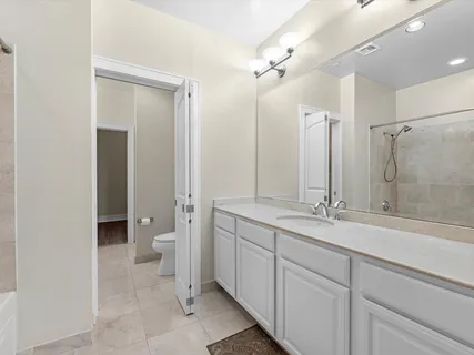 a bathroom with a double vanity sink mirror and toilet