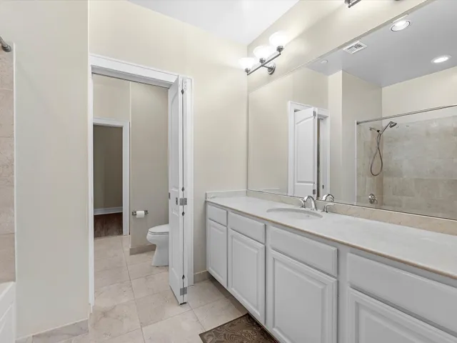 a bathroom with a double vanity sink mirror and toilet