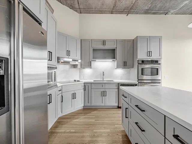 a kitchen with stainless steel appliances granite countertop a sink stove and refrigerator