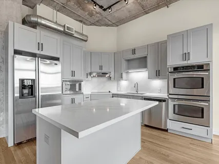 a kitchen with stainless steel appliances granite countertop a sink a stove and a refrigerator