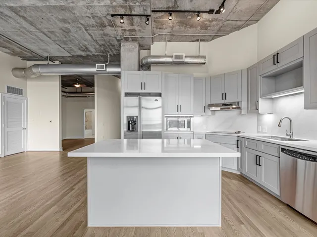a kitchen with stainless steel appliances granite countertop a sink a stove and cabinets