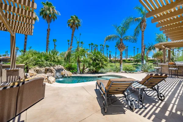 a view of a house with swimming pool and sitting area