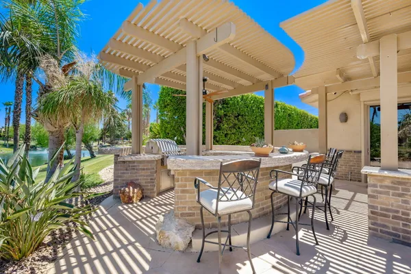 a view of a patio with dining table and chairs with a small yard