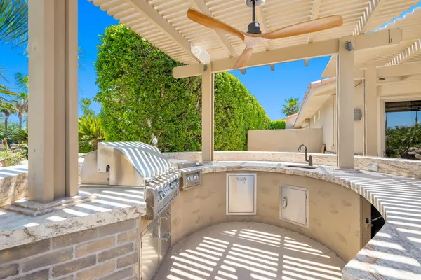 a view of a patio with a table and chairs under an umbrella