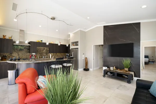 a living room with furniture a flat screen tv and kitchen view