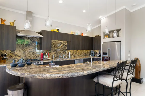 a kitchen with granite countertop a sink and chairs