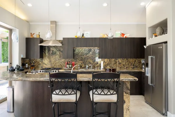 a kitchen with stainless steel appliances granite countertop a refrigerator and stove