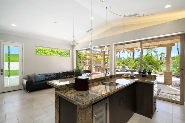 a room with furniture potted plant and open kitchen view