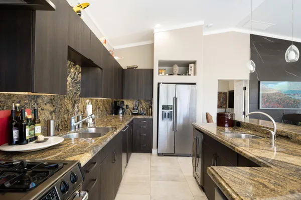 a kitchen with kitchen island granite countertop a sink appliances cabinets and a counter top space
