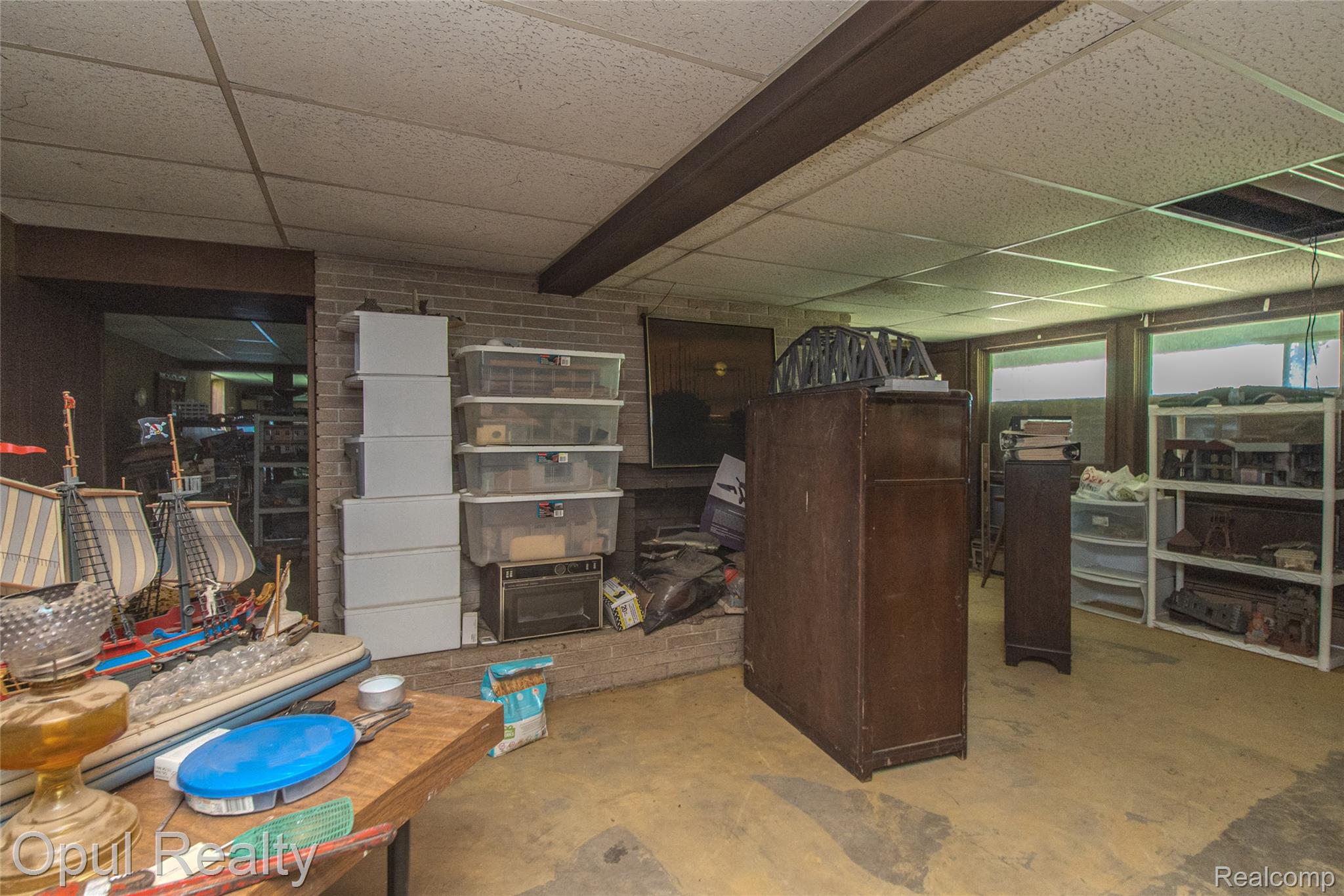 6455 Norham Road Bloomfield Hills, MI 48301 - Photo 70 of 93 Lower level interior featuring a drop ceiling, exposed support beam, brick wall, and multiple windows