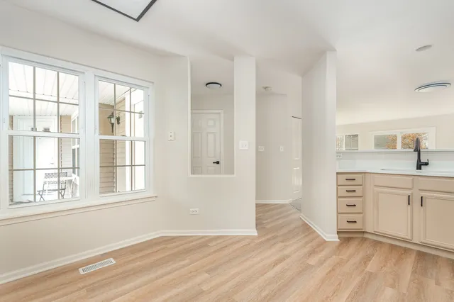 a view of a kitchen with wooden floor and cabinets