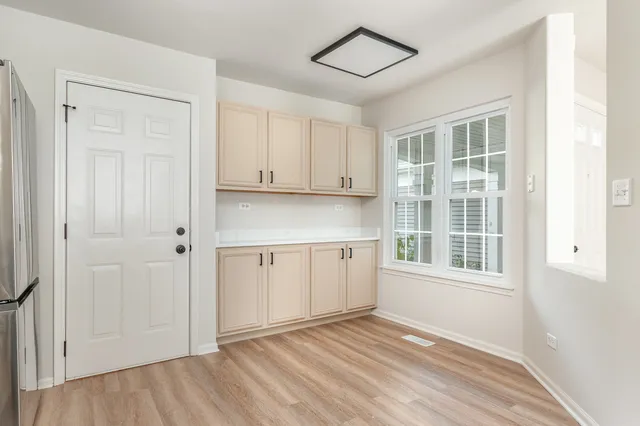 a view of a kitchen with wooden cabinet and a window
