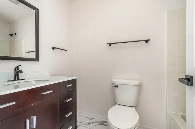 a bathroom with a toilet a sink and mirror