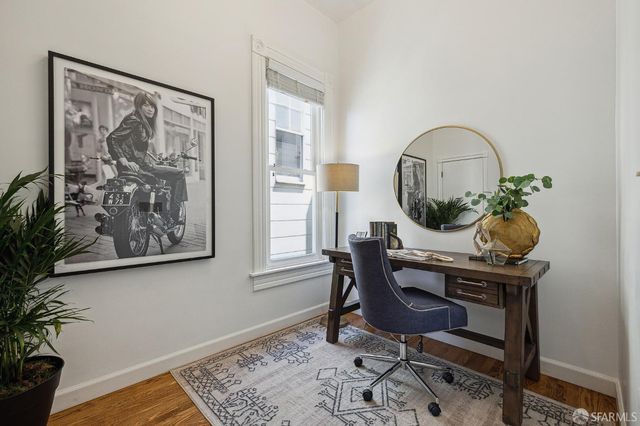 a view of a workspace room with furniture and a potted plant