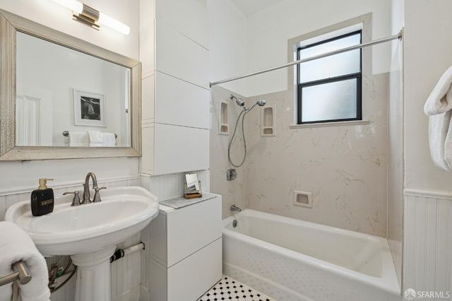 a bathroom with a sink a mirror and a bathtub