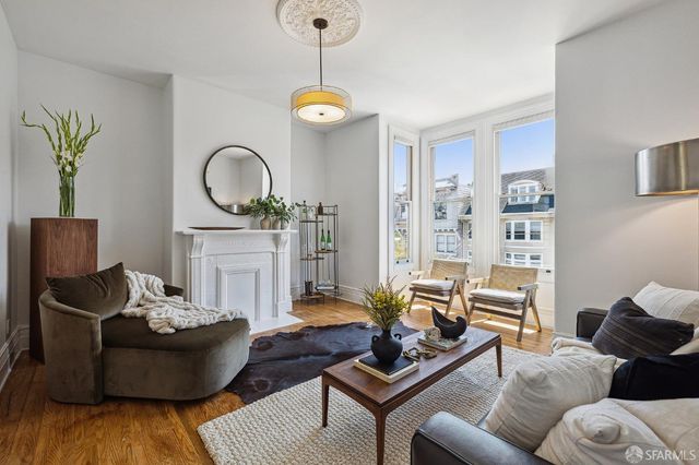 a living room with furniture a fireplace and a large window