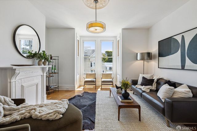 a living room with furniture a fireplace and a chandelier