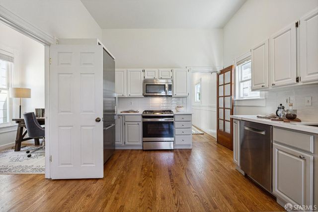 a kitchen with granite countertop a refrigerator and a stove top oven