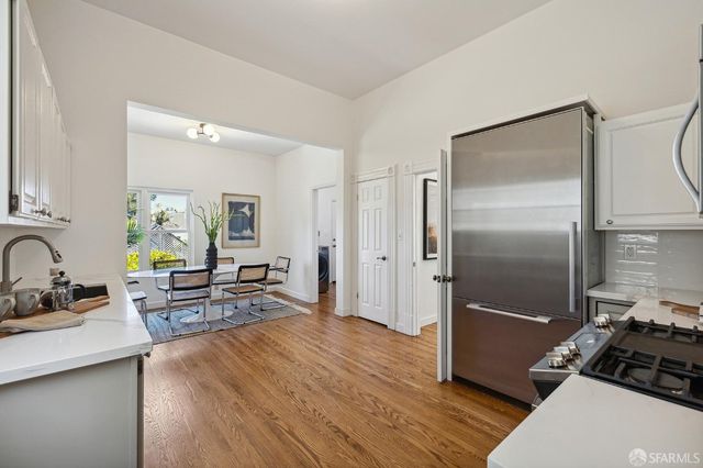 a kitchen with stainless steel appliances a refrigerator a stove a sink and white cabinets