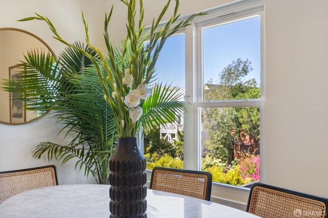 a vase of flowers sitting on a table with a potted plant