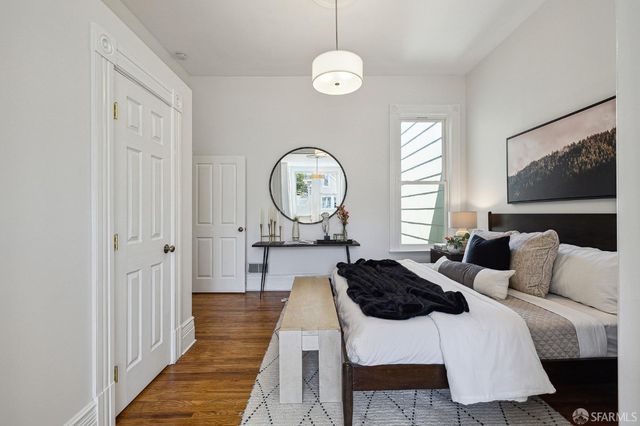 a bed room with a bed a mirror and a window