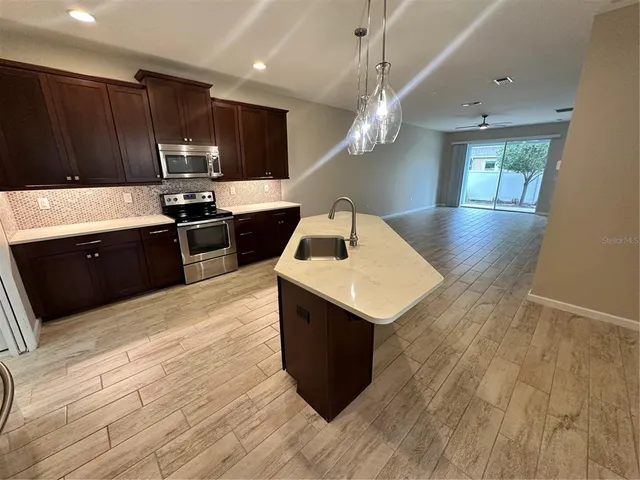 a kitchen with a sink cabinets and wooden floor