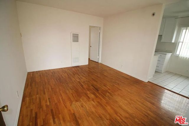 a view of a room with wooden floor and a window