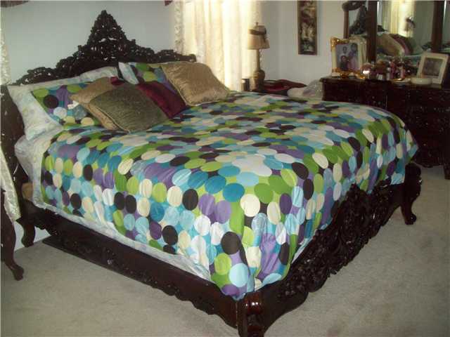613 Southwest Homeland Road Port St. Lucie, FL 34953 - Photo 2 of 4 a bedroom with a bed and a painting on the wall