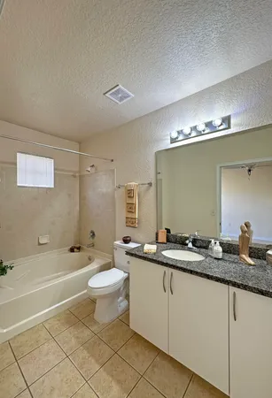a bathroom with a double vanity sink a toilet a mirror and shower