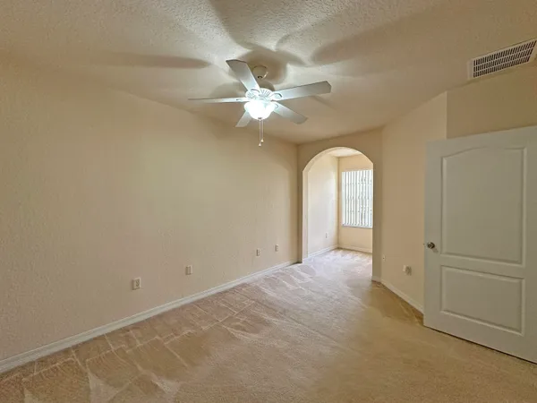 a view of a big room with closet and a ceiling fan