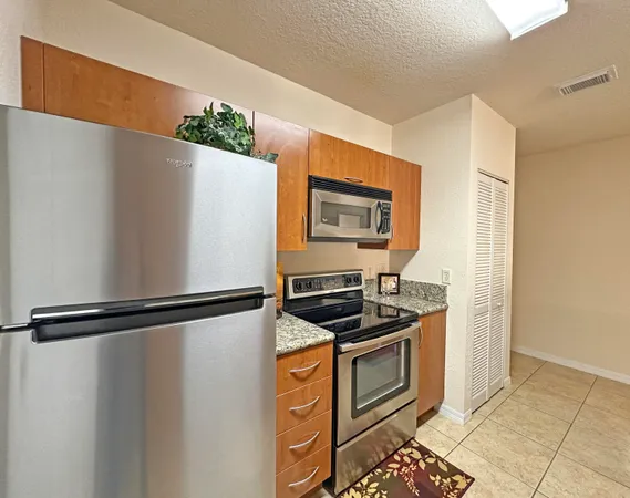 a kitchen with stainless steel appliances granite countertop a refrigerator sink and stove