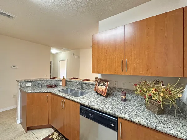 a kitchen with sink a mirror and cabinets